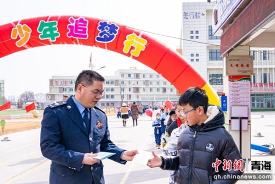 图为税务干部在校门口向同学们发放税法知识宣传册 。杨扬 摄 图为税务干部在校门口向同学们发放税法知识宣传册 。杨扬 摄