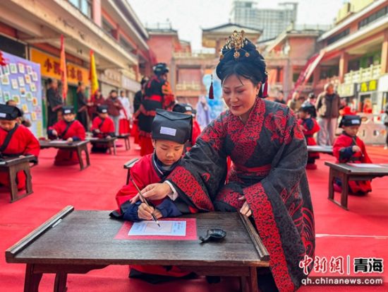 图为书法老师教授学童用毛笔写“人”字。马铭言 摄