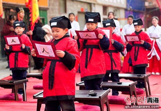 图为学童展示自己书写的“人”字后朗诵《三字经》。马铭言 摄