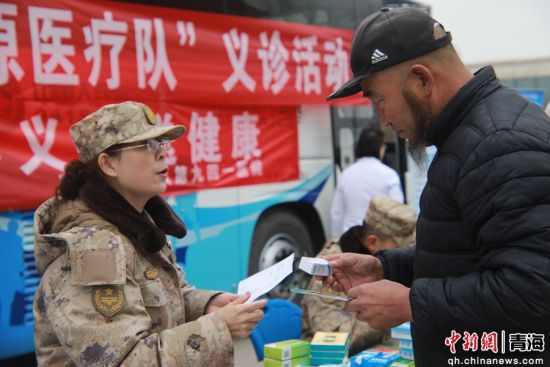 图为医疗队员给前来义诊的群众叮嘱服药事宜。 火光 摄