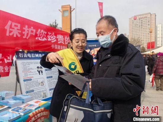 图为活动现场,银行工作人员向民众讲解有关“促进消费”的惠民政策和举措。 祁增蓓摄 图为活动现场,银行工作人员向民众讲解有关“促进消费”的惠民政策和举措。 祁增蓓摄