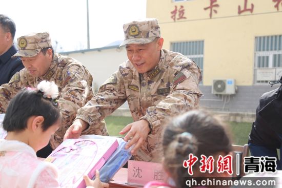 图为武警官兵向拉卡山村学生分发文具。 罗元凯摄 图为武警官兵向拉卡山村学生分发文具。 罗元凯摄