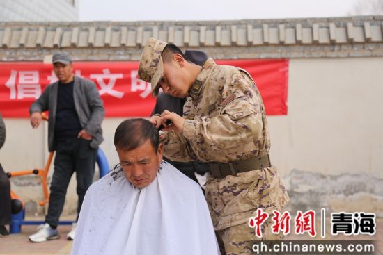 图为武警官兵给村民理发。 罗元凯摄 图为武警官兵给村民理发。 罗元凯摄