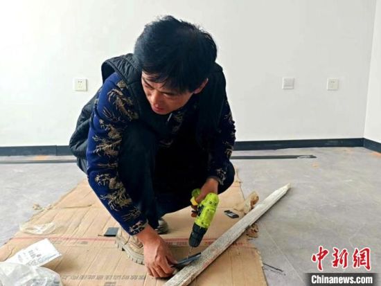 图为祁田林正在修整接待客人的房屋。俞惠珍 摄 图为祁田林正在修整接待客人的房屋。俞惠珍 摄