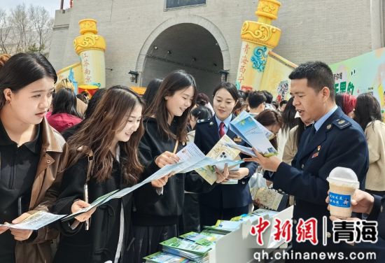 图为税务干部为来往游客讲解税费优惠政策。 秦慧卿 摄 图为税务干部为来往游客讲解税费优惠政策。 秦慧卿 摄