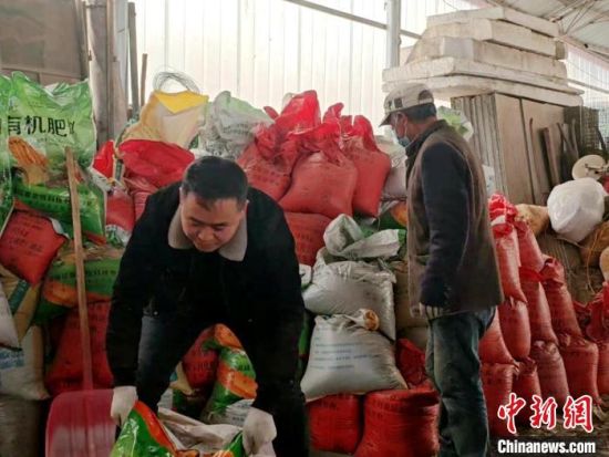 图为杨德龙(左)和父亲在仓库准备农资。俞惠珍摄 图为杨德龙(左)和父亲在仓库准备农资。俞惠珍摄