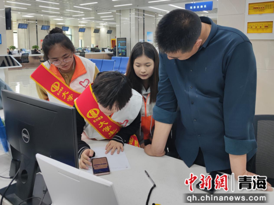图为“税收宣传志愿者”辅导纳税人填写代开发票基本信息。孙玥摄 图为“税收宣传志愿者”辅导纳税人填写代开发票基本信息。孙玥摄