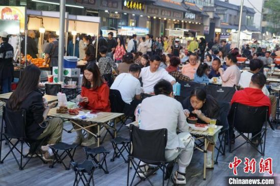 图为游客在西宁市城中区饮马街夜市就餐。马铭言摄 图为游客在西宁市城中区饮马街夜市就餐。马铭言摄