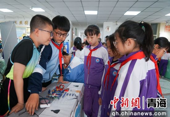 图为小发明《音量可调节简易收音机》吸引学生参观交流。 马铭言摄 图为小发明《音量可调节简易收音机》吸引学生参观交流。 马铭言摄