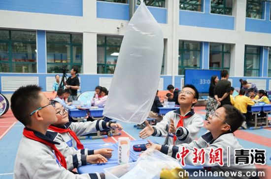 图为小学生进行小组合作赛实验,探索热空气上升的奥秘。 马铭言摄 图为小学生进行小组合作赛实验,探索热空气上升的奥秘。 马铭言摄
