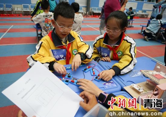 图为小学生进行小组合作赛《点亮小屋》的实验。 马铭言摄 图为小学生进行小组合作赛《点亮小屋》的实验。 马铭言摄