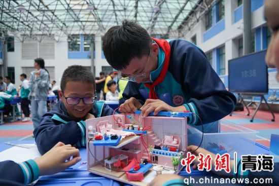 图为小学生进行小组合作赛《点亮小屋》的实验。 马铭言摄 图为小学生进行小组合作赛《点亮小屋》的实验。 马铭言摄