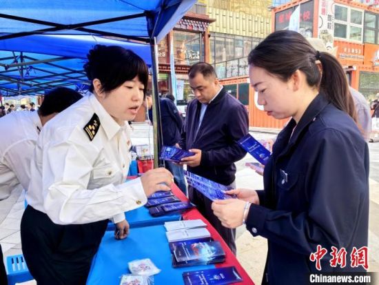 图为科技活动周现场,工作人员发放科普宣传册。 祁增蓓摄 图为科技活动周现场,工作人员发放科普宣传册。 祁增蓓摄