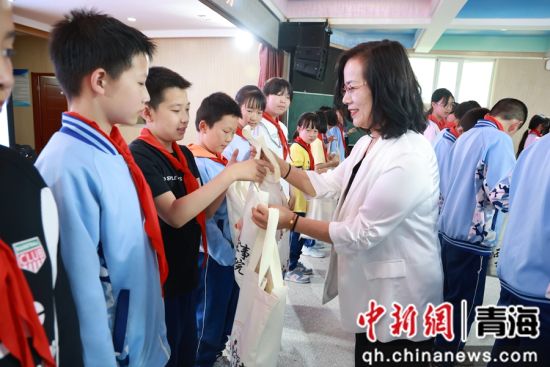 图为学校领导为军娃发放法治文创产品。张野 摄 图为学校领导为军娃发放法治文创产品。张野 摄