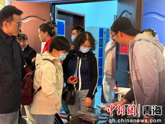 图为协会工作人员(右一)向民众科普无人机相关知识。祁绣娟 摄 图为协会工作人员(右一)向民众科普无人机相关知识。祁绣娟 摄