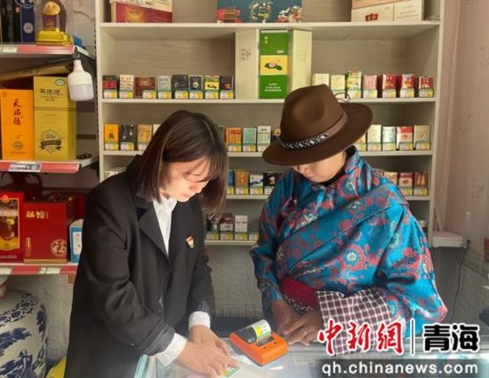 图为工作人员为少数民族零售客户打印粘贴卷烟标价签。海西州烟草专卖局供图 图为工作人员为少数民族零售客户打印粘贴卷烟标价签。海西州烟草专卖局供图
