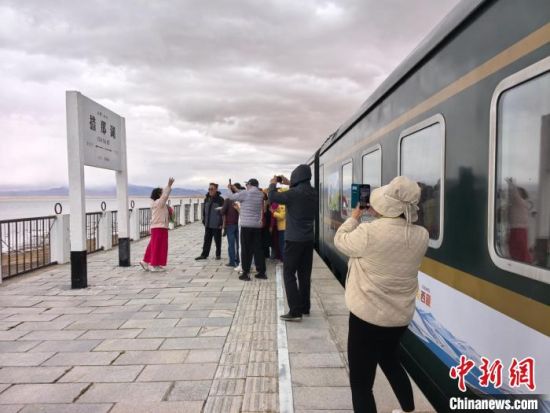 2025年6月1日，青海西宁直达西藏林芝旅游专列抵达措那湖，游客们“打卡”拍照。　　尤东方 摄
