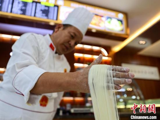 资料图为拉面匠人展示拉面技艺。薛蒂 摄