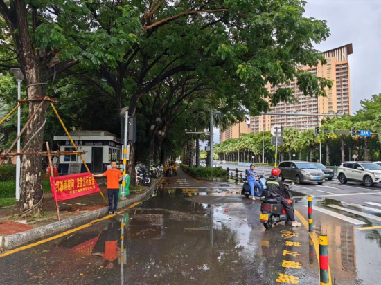 平安产险海南省理赔员在易涝路段悬挂警示横幅。