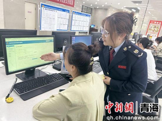 图为辅导纳税人进行操作登记。王百慧 摄 图为辅导纳税人进行操作登记。王百慧 摄