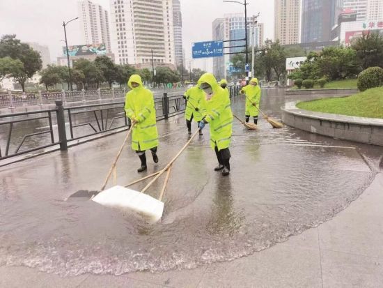 城中区市政公用服务中心防汛人员清理路面积水。季蓉 摄 城中区市政公用服务中心防汛人员清理路面积水。季蓉 摄