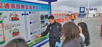 　青海省茫崖市公安局民警于一亮在冷湖镇苏干湖执勤卡点，向停车休息的游客宣讲道路交通安全知识。 　　受访者供图