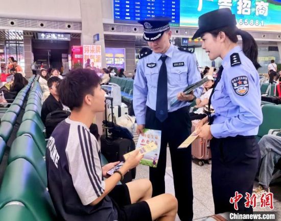 图为青藏铁路公安局西宁公安处民警向旅客发放禁毒知识宣传册。祁增蓓 摄 图为青藏铁路公安局西宁公安处民警向旅客发放禁毒知识宣传册。祁增蓓 摄