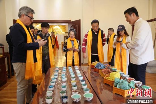 图为香港媒体代表团了解用于唐卡绘制的颜料。张海雯摄