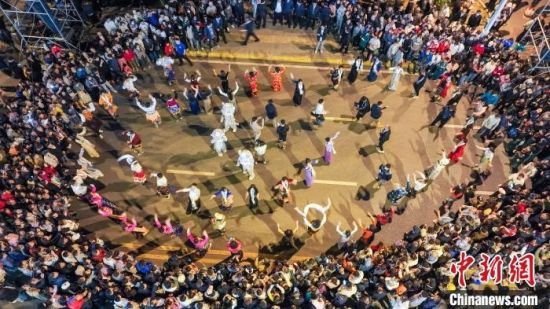图为西宁当地群众及游客在西宁城北区豹街·西海路美食街内跳起锅庄。黎晓刚摄 图为西宁当地群众及游客在西宁城北区豹街·西海路美食街内跳起锅庄。黎晓刚摄