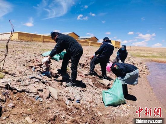 图为长江源村生态管护员巡护时捡拾垃圾。 青海省海西州格尔木市委组织部供图 图为长江源村生态管护员巡护时捡拾垃圾。 青海省海西州格尔木市委组织部供图