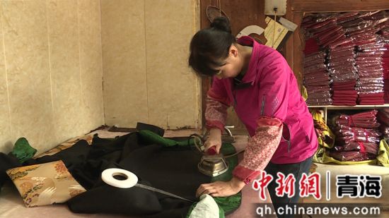 图为工作人员正在熨烫藏服。湟中融媒供图
