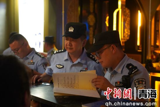 图为民警检查娱乐场所营业台账。共和融媒供图 图为民警检查娱乐场所营业台账。共和融媒供图