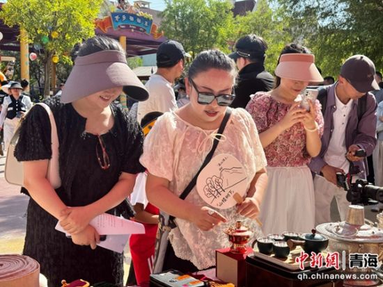 图为民众欣赏银铜器制作及鎏金技艺。祁绣娟 摄 图为民众欣赏银铜器制作及鎏金技艺。祁绣娟 摄