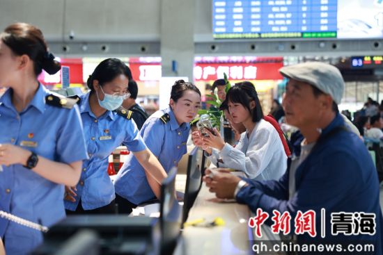 图为西宁车站客运车间客运员帮助旅客用手机app退票改签。 张炜摄