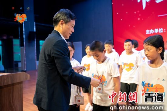 图为中国建设银行青海省分行党委委员、副行长刘建华为高原学子戴挂名牌。 刘洋 摄 图为中国建设银行青海省分行党委委员、副行长刘建华为高原学子戴挂名牌。 刘洋 摄