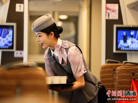 图为西宁客运段“动姐“为有需求旅客送上热水。 李磊摄