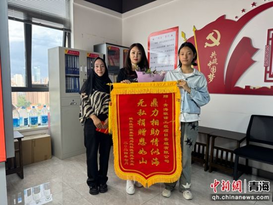 图为井女士母女为捐赠方赠送锦旗。 孙睿 摄 图为井女士母女为捐赠方赠送锦旗。 孙睿 摄