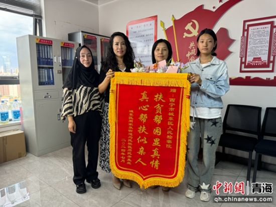 图为井女士母女为城东区检察院赠送锦旗。 孙睿 摄 图为井女士母女为城东区检察院赠送锦旗。 孙睿 摄