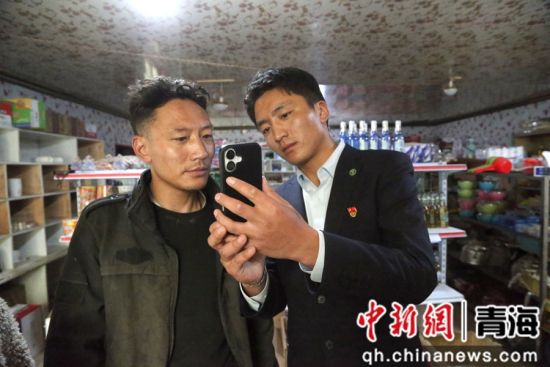 图为农行杂多县支行工作人员在查旦乡上门办理商户的收款码业务。 张忠苹 摄