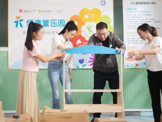 张雨绮、姜超安装“健康童乐园”物资。
