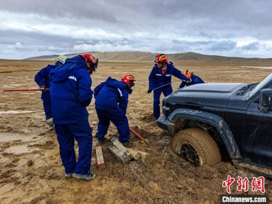 图为消防救援人员正在清理被困车辆轮胎周围淤泥。吴治国摄 图为消防救援人员正在清理被困车辆轮胎周围淤泥。吴治国摄