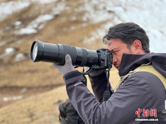 图为达杰在拍摄野生动物。李江宁 摄