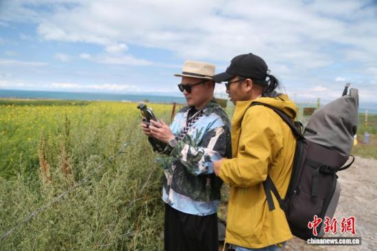 图为活动嘉宾正在采风拍摄。张忠苹 摄 图为活动嘉宾正在采风拍摄。张忠苹 摄