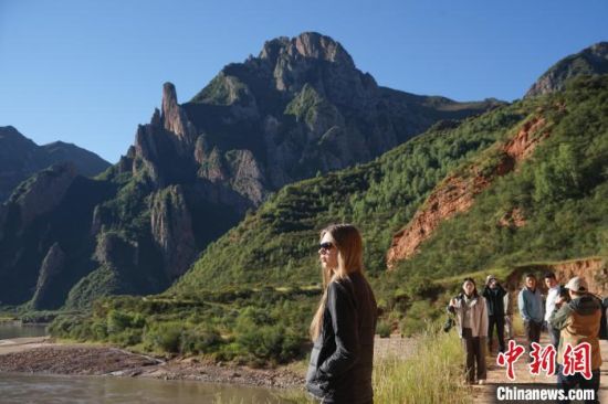 图为中外文旅达人在澜沧江上游的河谷中拍照打卡。马铭言 摄 图为中外文旅达人在澜沧江上游的河谷中拍照打卡。马铭言 摄