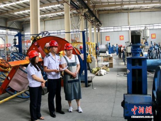 资料图为税务干部了解“小巨人”企业生产情况。赵沛 摄