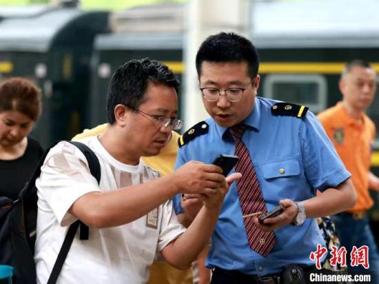 资料图为旅客向乘务人员咨询相关情况。青藏集团公司供图 资料图为旅客向乘务人员咨询相关情况。青藏集团公司供图