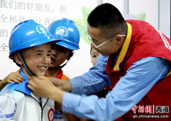 图为9月2日国网同仁市供电公司阿玮电力爱心服务队走进同仁市第一完全小学三年级二班开展安全用电进校园活动,现场为学生示范如何正确佩戴安全帽。祁正吉摄 图为9月2日国网同仁市供电公司阿玮电力爱心服务队走进同仁市第一完全小学三年级二班开展安全用电进校园活动,现场为学生示范如何正确佩戴安全帽。祁正吉摄
