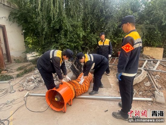 图为职工使用通风机进行井内通风。 朱琳琳摄