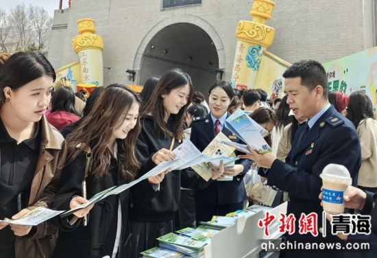 图为税务干部走进丹噶尔古城为来往游客讲解税费优惠政策。秦慧卿摄 图为税务干部走进丹噶尔古城为来往游客讲解税费优惠政策。秦慧卿摄