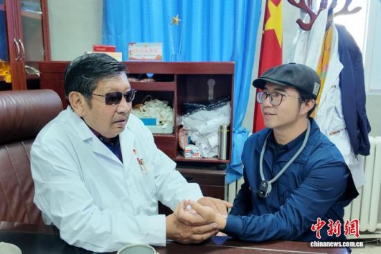 图为东杰为媒体记者把脉问诊。丁虎 摄